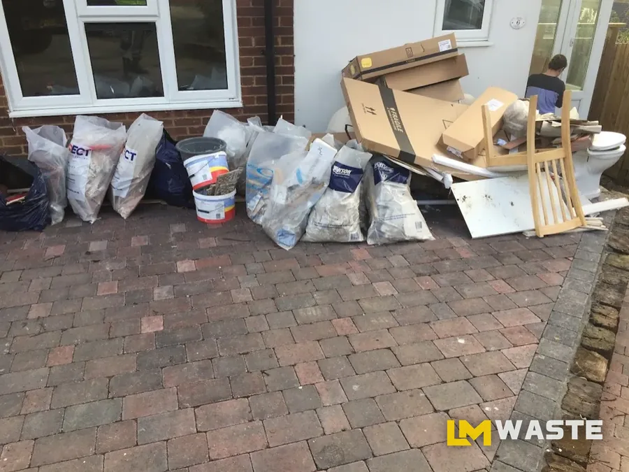 Bags and furniture on the drive from a house clearance